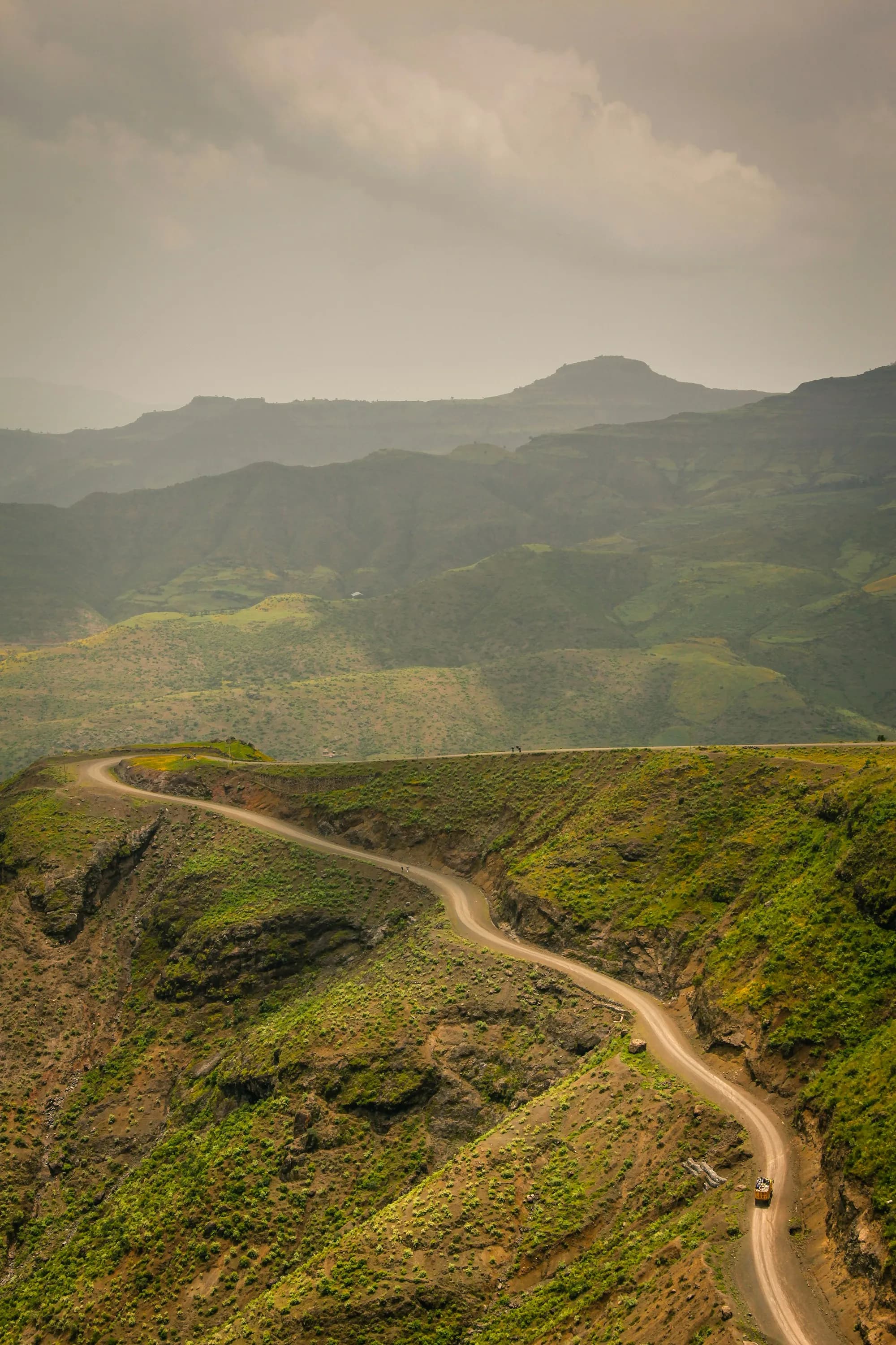 A road winding through green highland hills